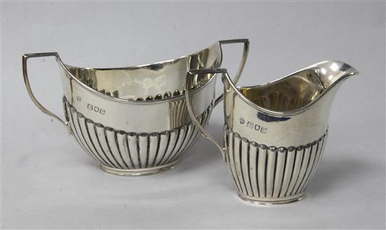 A late Victorian silver demi fluted sugar bowl and a cream jug.	